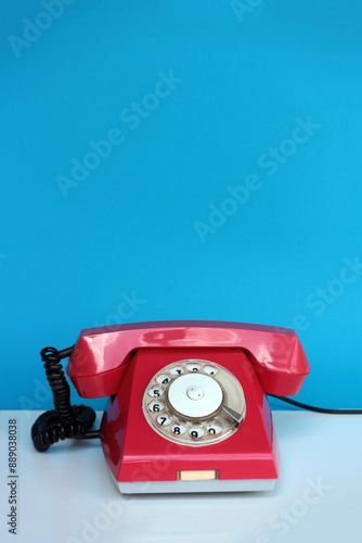 Old red Soviet telephone with a rotating dial