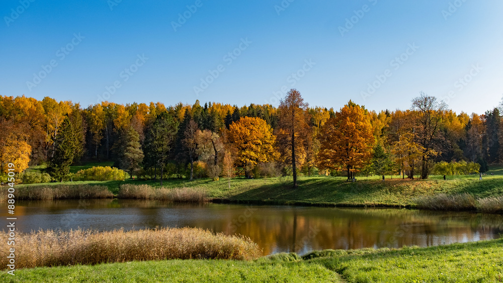 The tranquil beauty of a lakeside scene in autumn, with a tapestry of colorful trees reflecting on the calm water under the clear blue sky. Serene Lakeside Autumn Panorama The tranquil beauty of a lakeside scene in autumn, with a tapestry of colorful trees reflecting on the calm water under the clear blue sky. Serene Lakeside Autumn Panorama