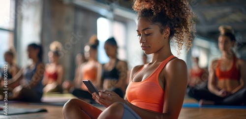 Young Woman Using Smartphone During Yoga Class in Modern Studio