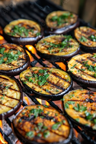 A plate of grilled eggplant with parsley on top. The eggplant is cooked and has a charred flavor