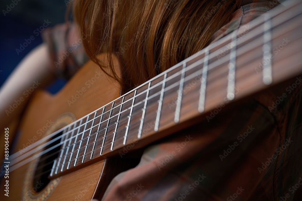 Fototapeta premium Cinematic shot close-up detail classic guitar and red girl learning to play guitar Music color 