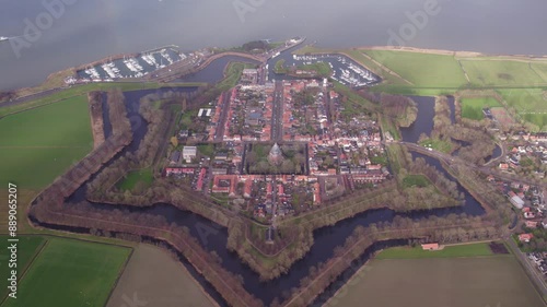 Aerial view of historic fortress, church, and city with colorful rainbow over river, Willemstad, Netherlands. photo