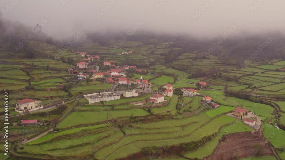 Aerial view of moody village with misty mountains and foggy fields, Labrujo, Viana do Castelo, Spain. Aerial view of moody village with misty mountains and foggy fields, Labrujo, Viana do Castelo, Spain.