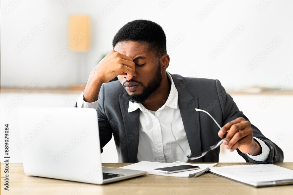 Overworked african american employee taking off glasses after hard day in office, copy space Overworked african american employee taking off glasses after hard day in office, copy space