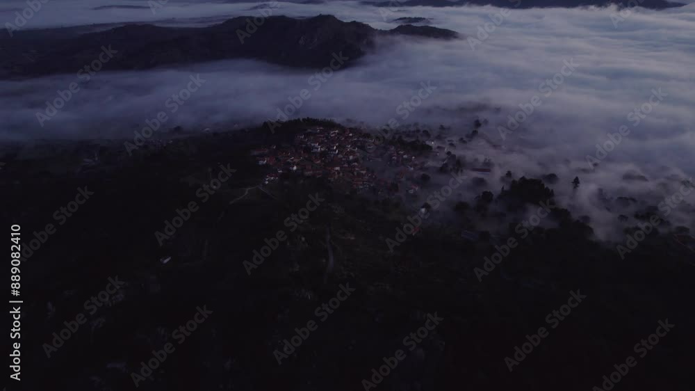 Aerial view of serene village with misty mountains, rocky church, and Torre de Lucano, Monsanto, Castelo Branco, Portugal. Aerial view of serene village with misty mountains, rocky church, and Torre de Lucano, Monsanto, Castelo Branco, Portugal.