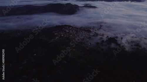 Aerial view of serene village with misty mountains, rocky church, and Torre de Lucano, Monsanto, Castelo Branco, Portugal. photo