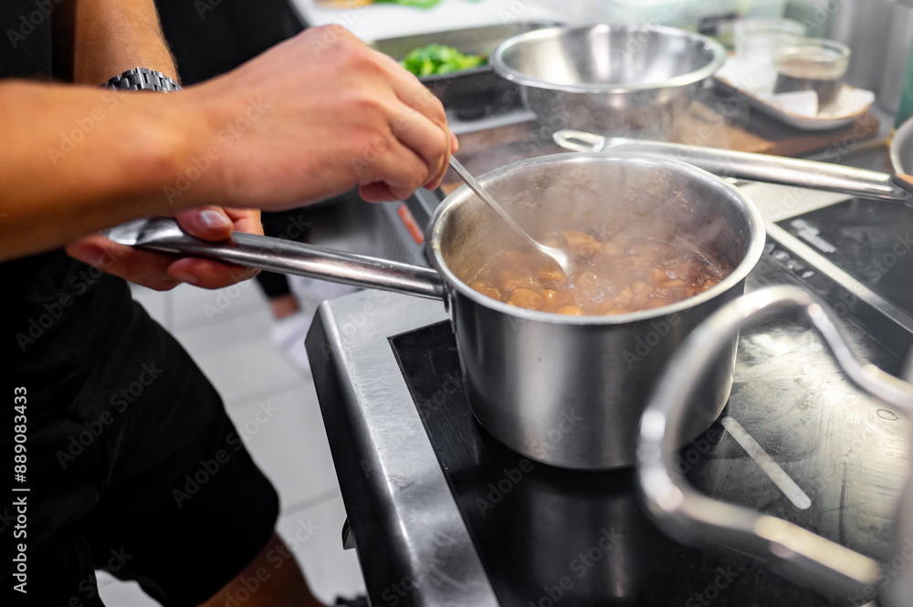 Close-up of hands stirring stew in a pot, emphasizing steam and texture Close-up of hands stirring stew in a pot, emphasizing steam and texture