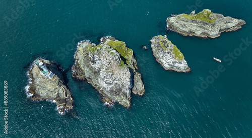 Aerial and top angle view of Oryukdo Islets with four rocky islands and a lighthouse with a fishing boat moored on the sea at Yongho-dong of Nam-gu, Busan, South Korea
 photo