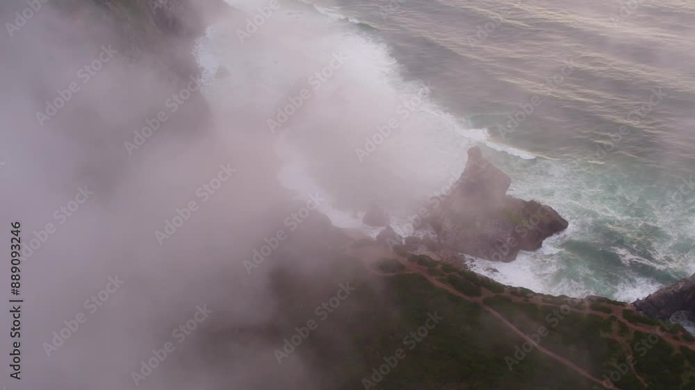 Aerial view of cliff, beach, ocean, waves, shoreline, mist, and rock formations at Praia do Caneiro, Cabo da Roca, Portugal. Aerial view of cliff, beach, ocean, waves, shoreline, mist, and rock formations at Praia do Caneiro, Cabo da Roca, Portugal.