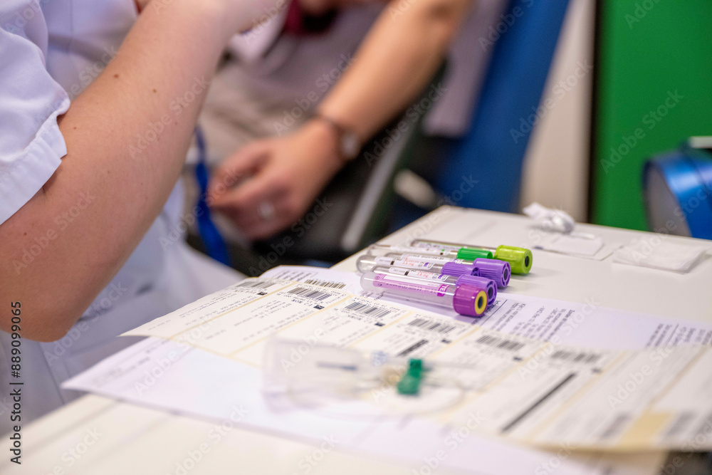 Medical professional in a white coat handling blood sample tubes over paperwork at a laboratory station. Medical professional in a white coat handling blood sample tubes over paperwork at a laboratory station.