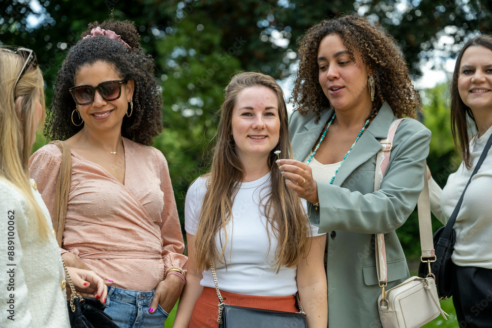 A group of women enjoying a conversation outdoors with trees in the background. A group of women enjoying a conversation outdoors with trees in the background.