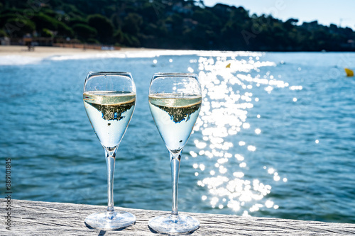 Summer time in Provence, two glasses of cold champagne cremant sparkling wine on famous Pampelonne sandy beach near Saint-Tropez in sunny day, Var department, France, beach club party photo