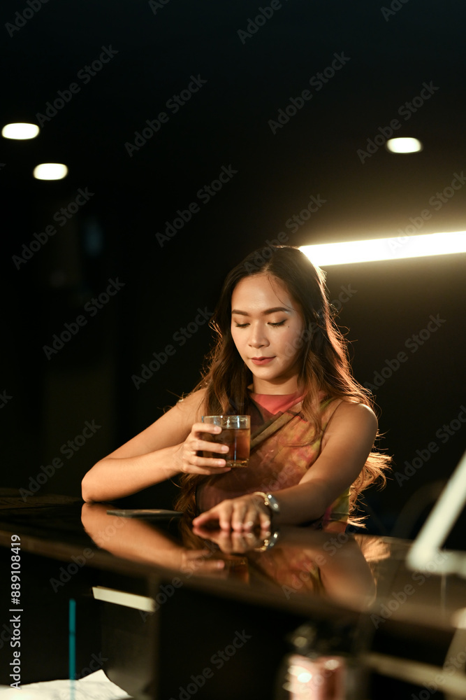 Portrait of elegant young woman relaxing with glass of whiskey at bar counter. Nightlife concept Portrait of elegant young woman relaxing with glass of whiskey at bar counter. Nightlife concept