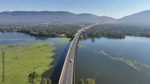 Traffic Over Bridge At Hartbeespoort North West South Africa. Birds Eye View Of Suspension Bridge With Cars Driving Across. Rural Road Valley Farming Amazing. Farming Tropical Countryside. photo