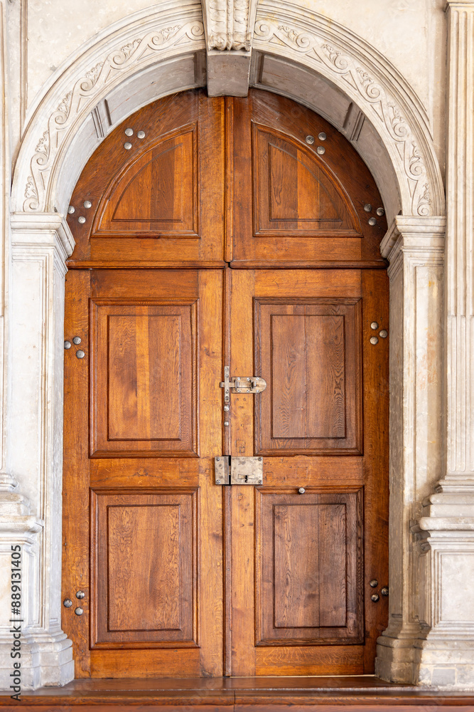Old wooden door with ornaments in a stone wall, usually used in cathedrals, churches, palaces and castles Old wooden door with ornaments in a stone wall, usually used in cathedrals, churches, palaces and castles