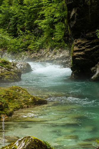 Vintgar Gorges Park a few km from Lake Bled, Slovenia. Wooden walkways accompany the path above the river rapids and waterfalls. River hits rocks and creates fog.Adventure family holidays. Freshness.