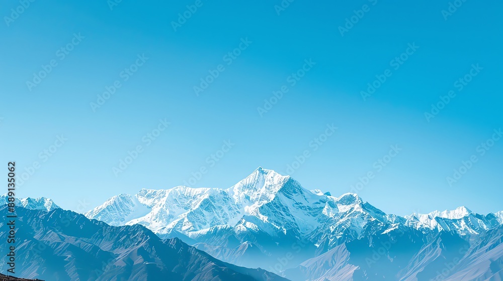 A snow-capped mountain range with a clear blue sky above. A snow-capped mountain range with a clear blue sky above.