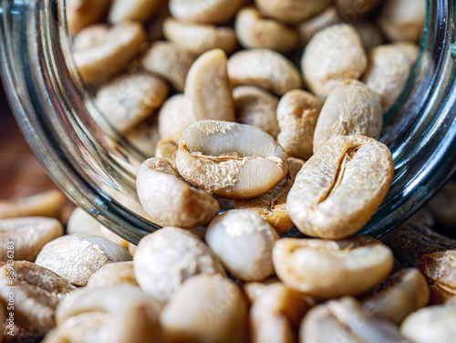 Green coffee beans poured out of a glass jar, Close-up of green raw coffee bean, unroasted coffee bean