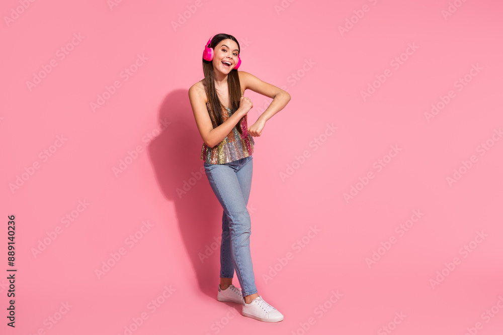 Full length photo of charming positive girl wear tank top headphones dancing empty space isolated pink color background Full length photo of charming positive girl wear tank top headphones dancing empty space isolated pink color background