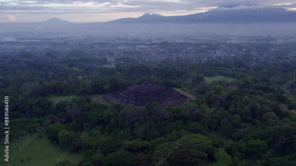 Aerial view of misty Borobudur temple surrounded by lush forest and mountains, Yogyakarta, Indonesia. Aerial view of misty Borobudur temple surrounded by lush forest and mountains, Yogyakarta, Indonesia.