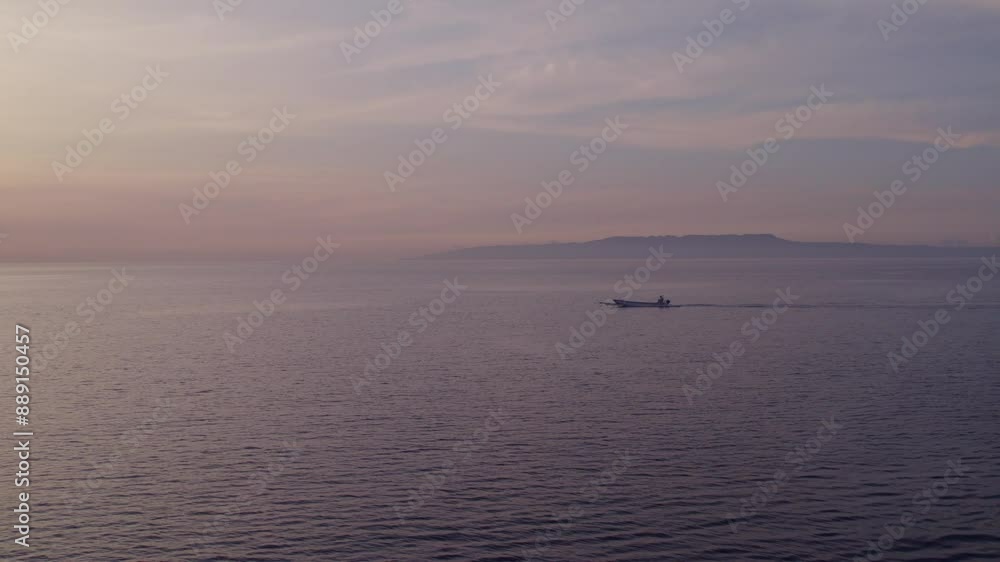 Aerial view of tranquil beach at sunrise with fishing boat and calm ocean, Karangasem, Bali, Indonesia. Aerial view of tranquil beach at sunrise with fishing boat and calm ocean, Karangasem, Bali, Indonesia.