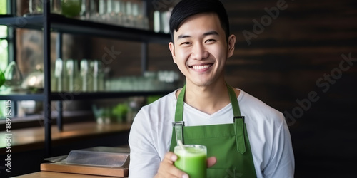 Happy young asian barista in cafe serving delicious green matcha tea to customers with smile photo