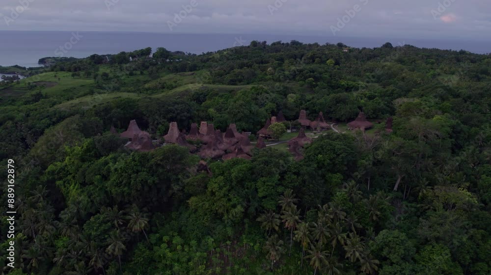 Aerial view of traditional village with lush forest, serene sea, and hills, Waru Wora, Sumba Island, Indonesia. Aerial view of traditional village with lush forest, serene sea, and hills, Waru Wora, Sumba Island, Indonesia.
