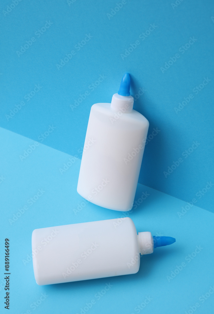 Two bottles of pva glue on blue background Two bottles of pva glue on blue background