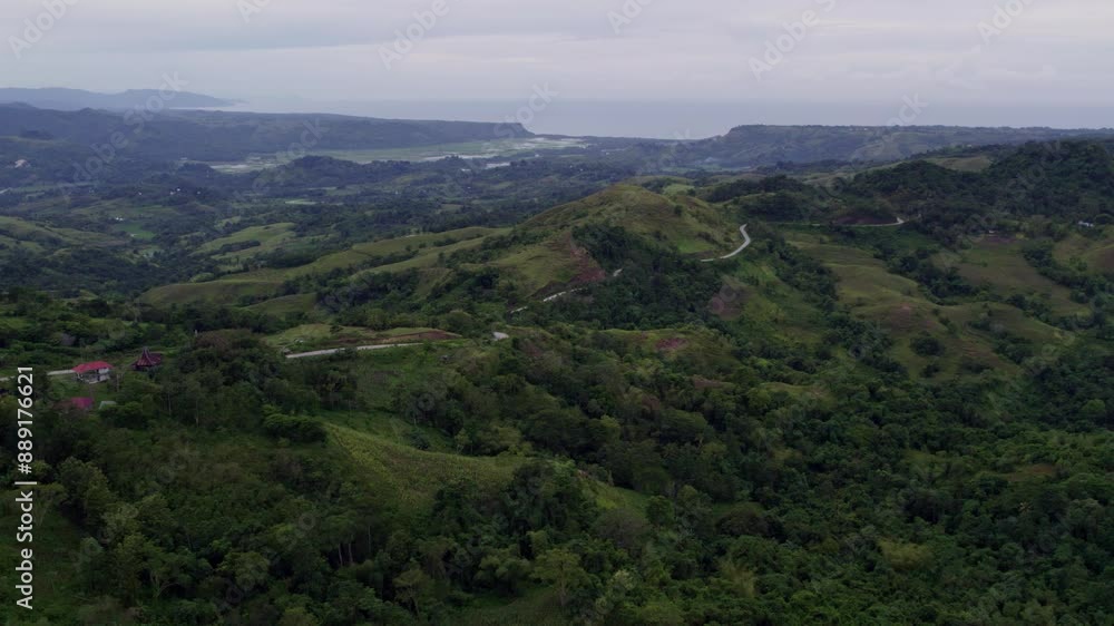 Aerial view of lush hills and winding road at sunset, Lapale Hills, Sumba Island, Indonesia. Aerial view of lush hills and winding road at sunset, Lapale Hills, Sumba Island, Indonesia.