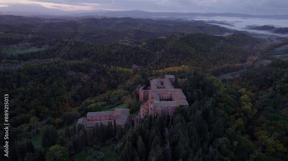 Aerial view of Abbey surrounded by forest and mountains at sunrise, Monte Oliveto Maggiore, Italy. Aerial view of Abbey surrounded by forest and mountains at sunrise, Monte Oliveto Maggiore, Italy.