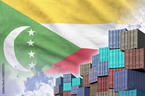 Comoros flag and big stack of shipping cargo containers in docks with sky background close up photo