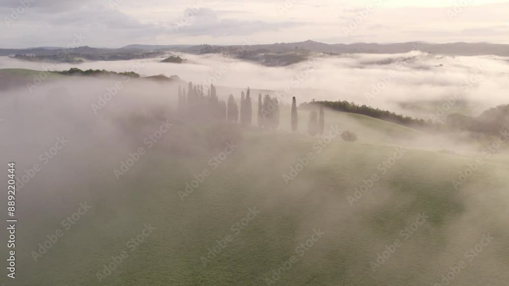 Aerial view of misty countryside with rolling hills, villa, and cypress trees, Asciano, Tuscany, Italy. Aerial view of misty countryside with rolling hills, villa, and cypress trees, Asciano, Tuscany, Italy.