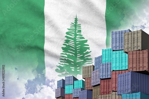 Norfolk island flag and big stack of shipping cargo containers in docks with sky background close up