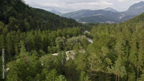 Aerial view of lush forest, meandering river, and majestic mountains in Golling an der Salzach, Austria. photo