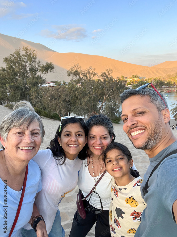 Obraz premium A family of five is posing for a photo on a Huacachina Oasis. Peru
