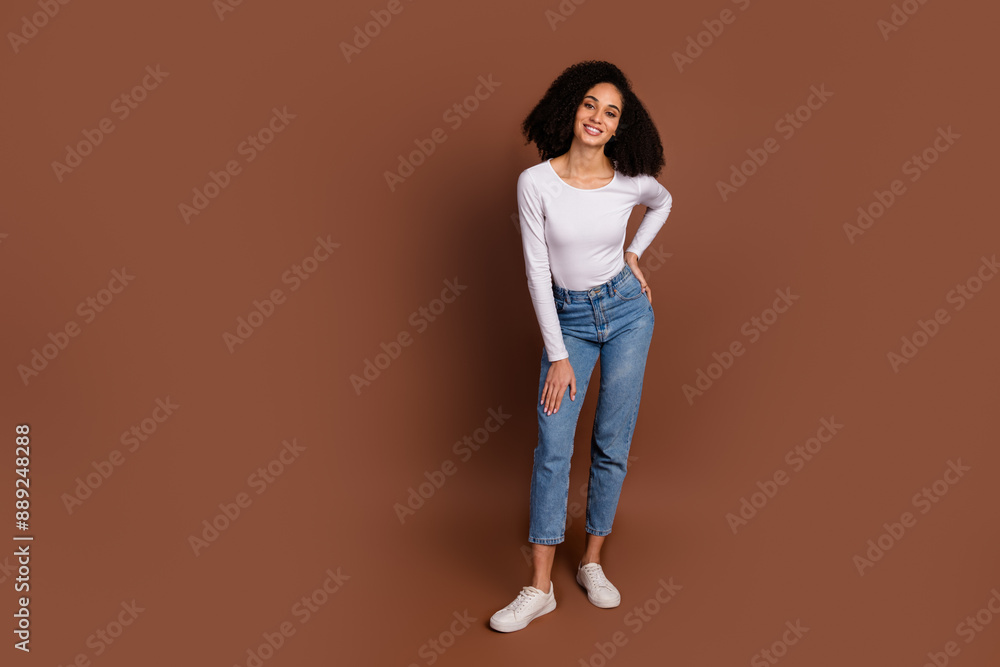 Full size photo of pretty young girl empty space wear pullover isolated on brown color background Full size photo of pretty young girl empty space wear pullover isolated on brown color background