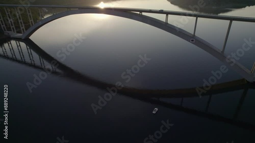 Aerial view of sunrise over the Adriatic Sea with bridge, traffic, and boats, Krk, Primorje-Gorski Kotar, Croatia. photo