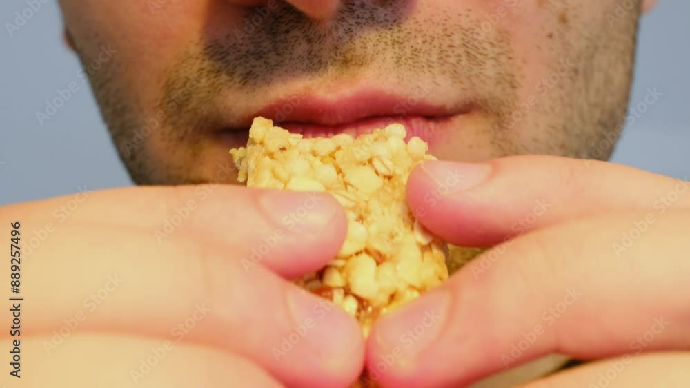 person eating a nut bar person eating a nut bar