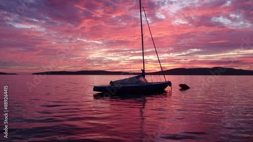 Aerial view of colourful sailing boat in serene sea at sunset, Brodarica, Croatia. photo