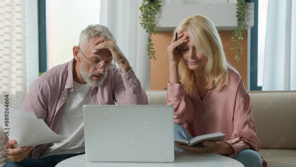 Angry upset 50s married senior elderly Caucasian couple woman female mature man male businesspeople family bankruptcy business documents paper laptop speak bill money debt problem scam home bad result Angry upset 50s married senior elderly Caucasian couple woman female mature man male businesspeople family bankruptcy business documents paper laptop speak bill money debt problem scam home bad result