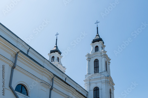 white Catholic church towers with crosses looking up into the blue sky