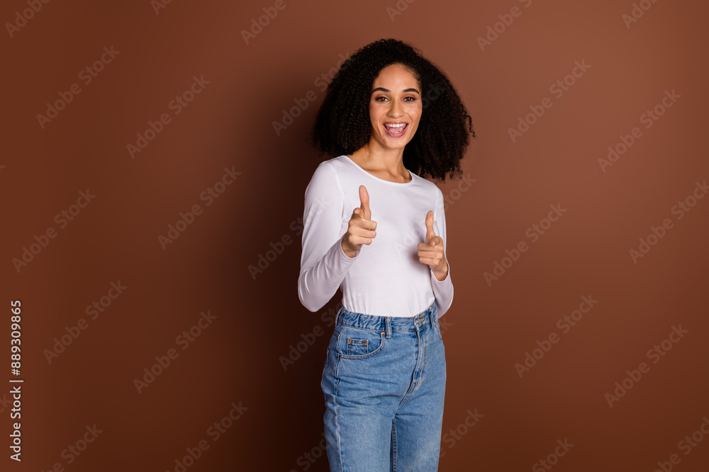 Photo of pretty young girl point fingers you wear pullover isolated on brown color background Photo of pretty young girl point fingers you wear pullover isolated on brown color background