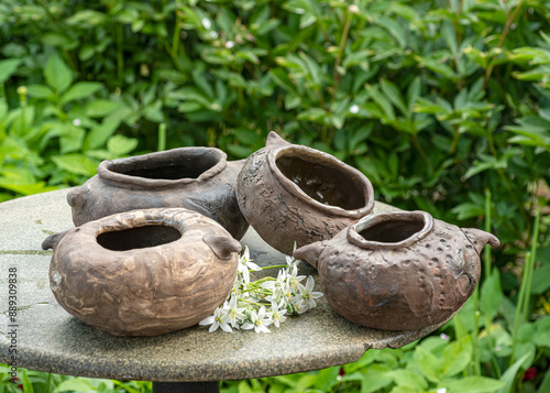 Obraz na plátně still life with decorative earthenware on a background of green plants, handmade