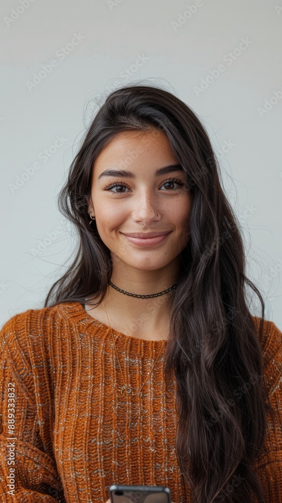 Smiling girl looking at camera holding smartphone on isolated background Smiling girl looking at camera holding smartphone on isolated background