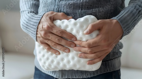 A person holding a hot water bottle to their lower abdomen for pain relief