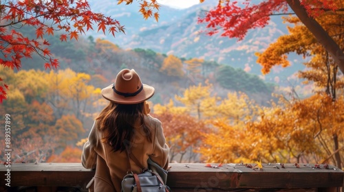 woman crossing a wooden bridge surrounded by forest in autumn photo