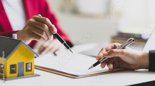 Fotografie Businesswoman discusses with real estate agent, negotiates and signs contract for purchase of house and land