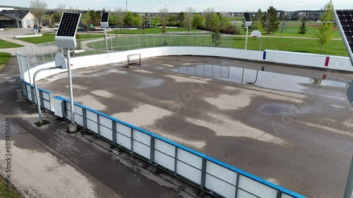 Airdrie Alberta Canada, May 25 2024: Solar panels LED light combo unit overlooking outlook basketball courts and hockey rink tracking shot.
 photo