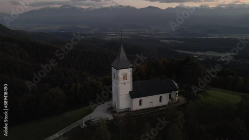 Aerial view of St. Primoz church at sunrise with Julian Alps peaks, Jamnik, Slovenia. photo