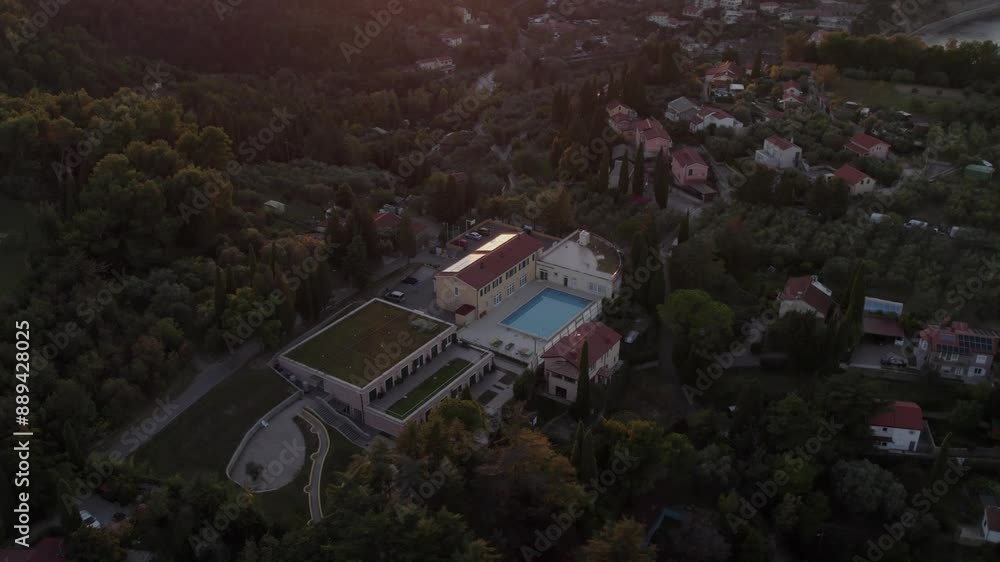 Aerial view of tranquil village with pool, forest, hills, and sunset, Piran, Slovenia. Aerial view of tranquil village with pool, forest, hills, and sunset, Piran, Slovenia.